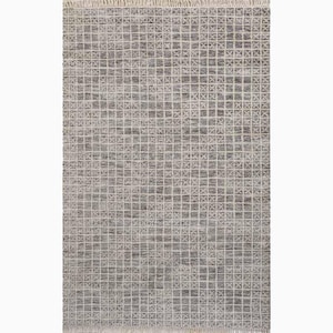 Puede incluir: Una alfombra rectangular con un patrón de cuadrícula geométrica en tonos grises y blanquecinos. La alfombra tiene una apariencia texturizada y un detalle de flecos en un borde. El diseño presenta un motivo cuadrado repetitivo.