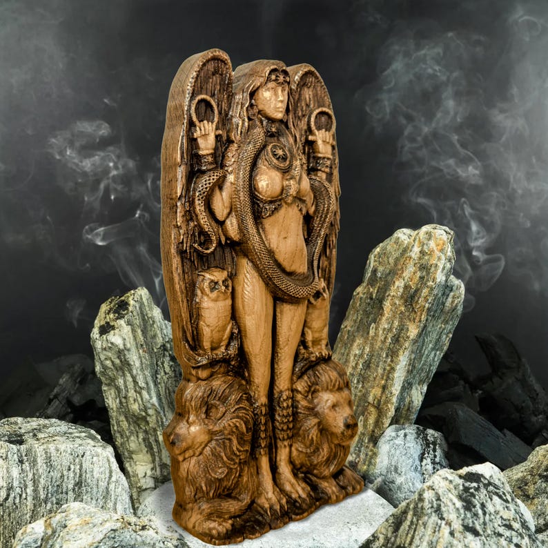 May include: A wooden statue of a female figure with wings, a snake, and owls. The figure is standing on two lions. The statue is brown and has a rustic finish.