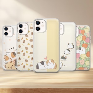 May include: Five clear smartphone cases featuring various illustrations of guinea pigs. Designs include guinea pigs with carrots, a split yellow background with two guinea pigs and a heart, a trail of guinea pigs, and a pattern of colorful tulips.