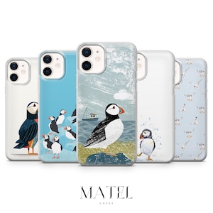 Könnte beinhalten: Fünf Handyhüllen mit Illustrationen von Papageientauchern. Die Designs umfassen Papageientaucher auf blauem Hintergrund, eine Seelandschaft mit einem Boot und ein Muster von Möwen. Der Markenname "MATEL CASES" ist unten abgebildet.