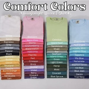 a collection of various colored T-shirts, each with a different color name written on it. The T-shirts are arranged in a row, showcasing a range of colors from white to blue.