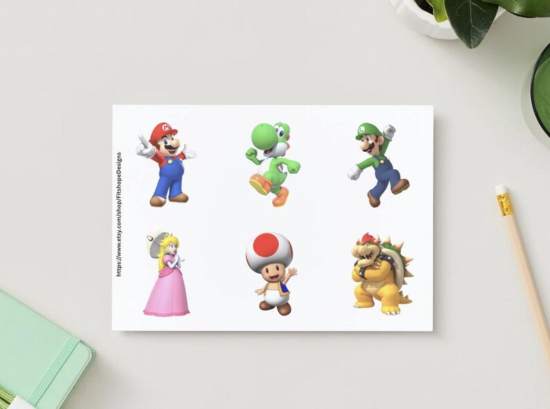 May include: A white card featuring six colorful illustrations of characters from the Super Mario video game series. The characters include Mario, Luigi, Yoshi, Princess Peach, Toad, and Bowser. The Etsy shop URL is visible on the card.