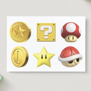 May include: A white card featuring six colorful icons from the Super Mario video game series. Includes a gold coin with a star, a yellow question mark block, a red and white mushroom, a gold coin, a yellow star, and a red turtle shell.