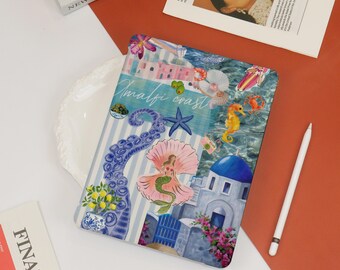 May include: A colorful phone case with a blue and white striped background. The case features a mermaid, an octopus, a seashell, a starfish, and a building with a blue dome. The text "Amalfi coast" is written in white letters on a blue background.
