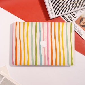May include: A laptop case with a colorful striped pattern in shades of yellow, orange, pink, blue, and green. The case has a white Apple logo in the center.