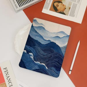 May include: A blue and white laptop skin with a design of abstract waves. The waves are made up of thin lines that create a textured look.