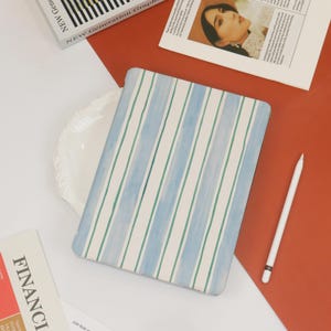 May include: A white and blue striped laptop sleeve with a watercolor effect. The sleeve is made of a soft, durable material and is perfect for protecting your laptop from scratches and bumps.
