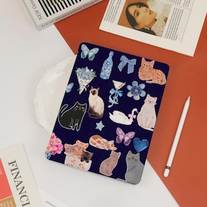 May include: A blue and white laptop case with a variety of colourful stickers featuring cats, butterflies, flowers, and other designs.