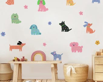 May include: A collection of colorful dog wall decals in various breeds and colors, including pink, blue, and orange. The decals are scattered across a white wall, with flower accents. A wooden bench with a rainbow and toy train is in the foreground.
