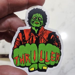 May include: Green and red sticker featuring a zombie Michael Jackson with the word "Thriller" spelled out in red letters across his fists.