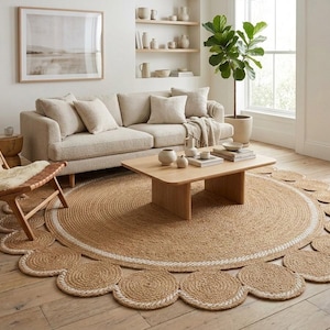 Pu&ograve; includere: Un tappeto rotondo in juta con bordo smerlato e bordo bianco. Il tappeto si trova in un soggiorno con un divano beige, un tavolino in legno e una sedia in legno con un rivestimento in pelle di pecora.