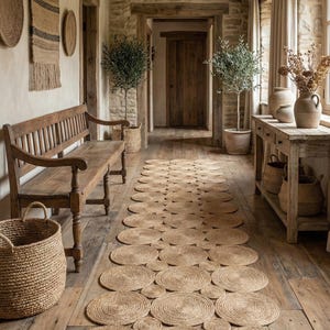 May include: A rustic hallway featuring a long, circular jute rug. The rug is made of natural fibers and complements the wooden bench, baskets, and distressed wooden console table. The walls are stone and the floors are wood.