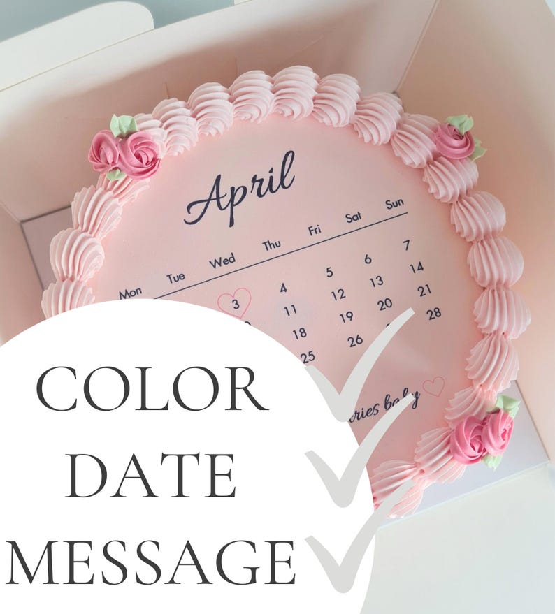 May include: A pink cake with a calendar design for April, decorated with pink frosting swirls and small rose accents. The cake is in a box, with the words "COLOR DATE MESSAGE" overlaid on the image.