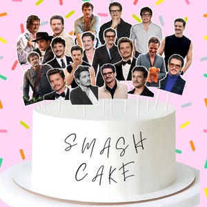 May include: A white smash cake with the words "SMASH CAKE" in black script. The cake is decorated with multiple images of a person on sticks. The background is pink with colorful sprinkles.