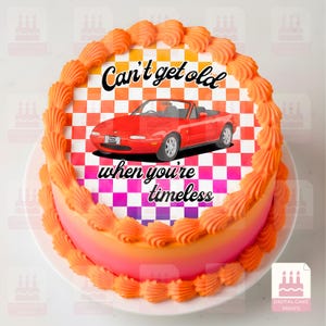 Puede incluir: Tarta redonda con glaseado naranja y una imagen de un coche descapotable rojo. La tarta tiene el texto "Can't get old when you're timeless" sobre un fondo a cuadros. La tarta está decorada con glaseado naranja en los bordes.