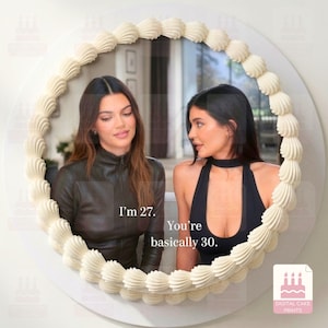 Könnte beinhalten: Ein runder Spiegel mit einem weißen, aufgespritzten Zuckergussrand, der ein gedrucktes Bild von zwei Personen mit dem Text I'm 27. You're basically 30. zeigt. Der Spiegel hat einen dekorativen Rand, der an Tortenguss erinnert.