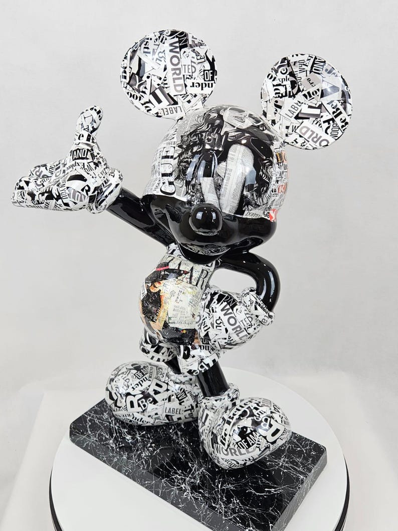 Pode incluir: Figurine de Mickey Mouse em preto e branco vestindo uma camisa com padr&atilde;o preto e branco. A figurine est&aacute; em p&eacute; sobre uma base preta e branca. A figurine &eacute; feita de resina e tem aproximadamente 30 cm de altura.