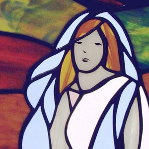 May include: A stained glass window featuring a woman with long red hair, wearing a white veil and a white dress. The background is a colourful abstract design.