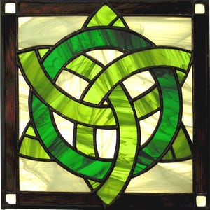 May include: A stained glass window featuring a Celtic knot design. The knot is formed from three interlacing loops, and the glass is cut into small pieces to create a textured effect.