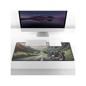 May include: A black and brown motorcycle on a winding road with green trees and a blue sky. The motorcycle is in the foreground and the road is in the background. The image is a digital illustration.