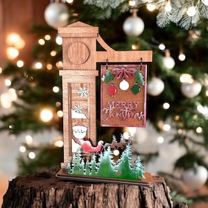 May include: Wooden Christmas sign with a red and green "Merry Christmas" sign, a Santa Claus figure in a sleigh, and a green forest scene. The sign is decorated with red and green ornaments and a bow.