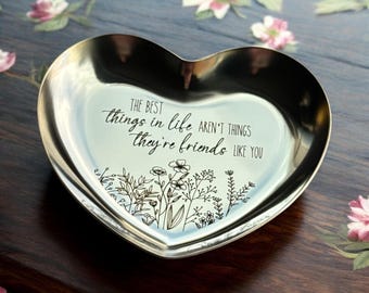 May include: A silver heart-shaped trinket dish with the inscription "The best things in life aren't things they're friends like you" and a floral design.