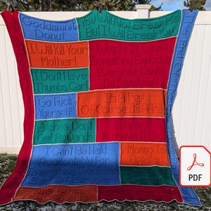 May include: A large, colorful crocheted blanket with various phrases in different colors. The blanket features text like "Goddammit Donut," "I Will Kill Your Mother!," and "I Can't Be Held Accountable." The blanket is displayed outdoors.