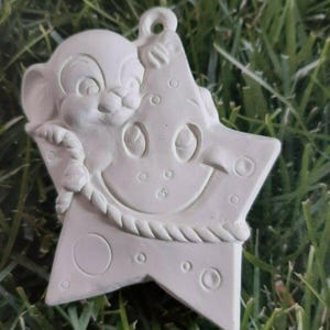 May include: White ceramic ornament of a cartoon mouse holding a star with a smiley face. The star has a rope design around the edge.