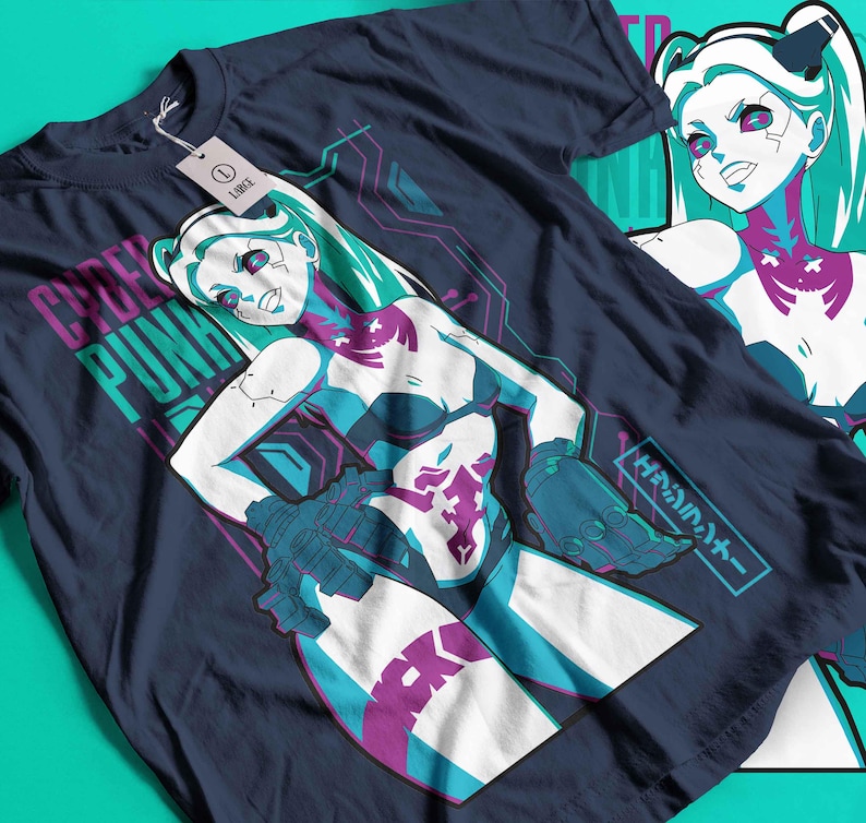 May include: Dark blue t-shirt with a graphic of a female anime character with teal hair and accents. The shirt has the words "CYBER PUNK" printed in teal and pink. A tag is attached to the shirt.
