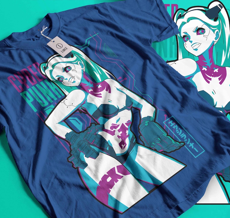 May include: A blue t-shirt with a graphic of a female anime-style character with teal hair and accents. The shirt has the words "CYBER PUNK" printed on it. The design incorporates white, teal, and purple colours.