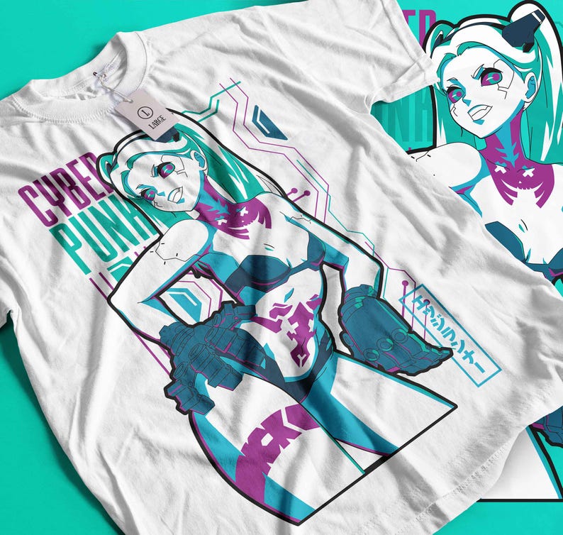 May include: White t-shirt with a graphic of a female anime-style character with teal hair and accents. The shirt has the words "CYBER PUNK" in purple and teal. Another shirt is visible in the background.