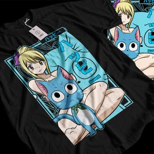 May include: Black t-shirt featuring a colorful anime-style graphic. The design includes a blonde-haired character and a blue cat-like creature with large eyes. The Japanese word "Happy" is also present in the design. A white tag is attached to the shirt.
