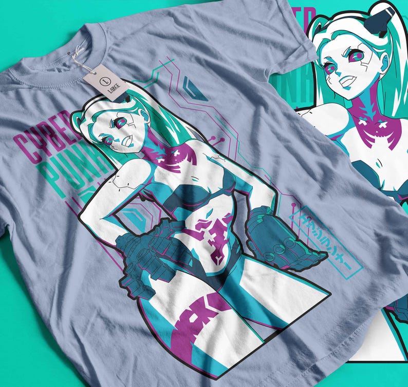 May include: A pale blue t-shirt with a cyberpunk illustration. The design features a female character with teal hair and accents, and the words "CYBER PUNK" in purple and teal. A tag reads "LARGE".