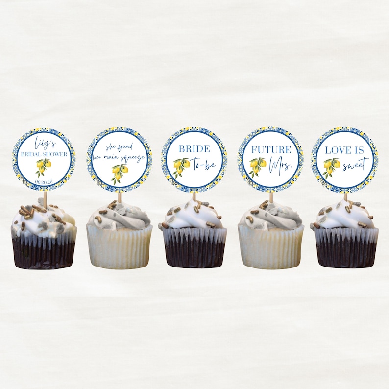 May include: Five cupcakes with white frosting and chocolate cake bases. Each cupcake has a circular topper with text and a lemon design. The toppers read: "Lily's Bridal Shower", "she found her main squeeze", "BRIDE To-be", "FUTURE Mrs.", and "LOVE IS sweet".