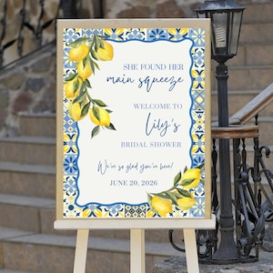 May include: A welcome sign for a bridal shower, featuring a lemon and floral design. The sign reads "She found her main squeeze, Welcome to Lily's Bridal Shower. We're so glad you're here! June 20, 2026."