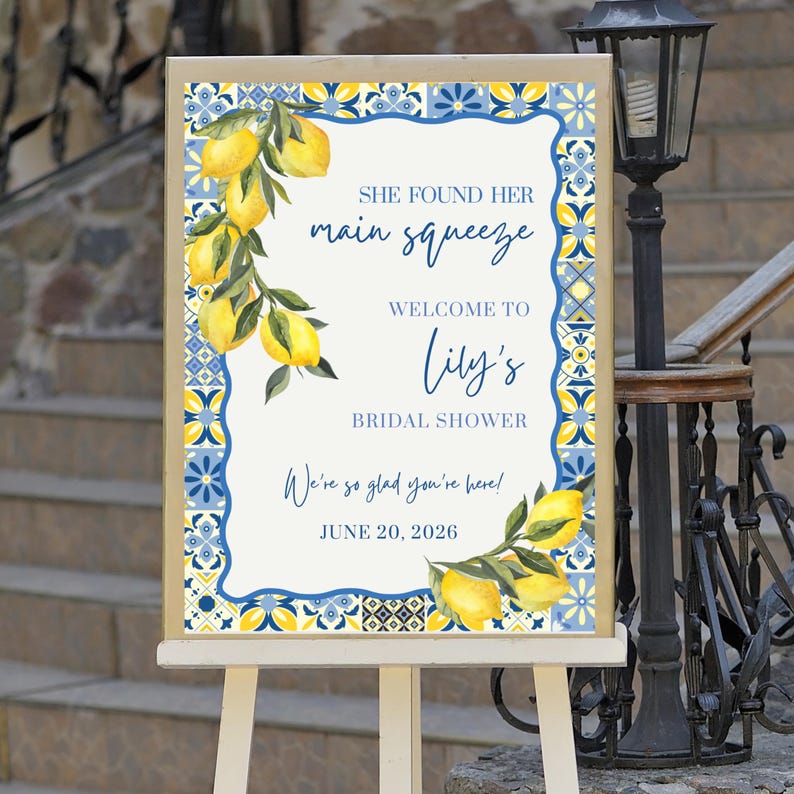 May include: A welcome sign for a bridal shower, featuring a lemon and floral design. The sign reads "She found her main squeeze, Welcome to Lily's Bridal Shower. We're so glad you're here! June 20, 2026."