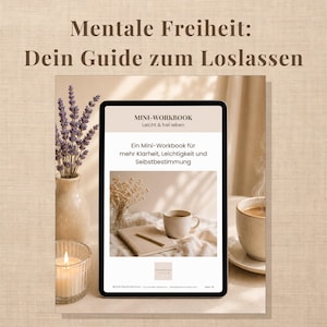 May include: A digital tablet displaying a mini-workbook titled Mentale Freiheit: Dein Guide zum Loslassen. The screen shows text in German, a coffee cup, a notebook, and dried flowers. The tablet is surrounded by a vase of lavender and a candle.