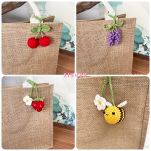 May include: Four close-up images of burlap tote bags, each decorated with a different crocheted charm. The charms include red cherries, purple grapes, a red strawberry with a white flower, and a yellow and black bee with a white flower.
