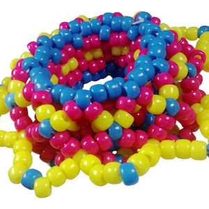 Op de afbeelding: Een kleurrijke kralenarmband in geel, blauw en roze. De kleine, cilindrische kralen zijn aan elkaar geregen tot een flexibele, cirkelvormige vorm. Een levendig accessoire.
