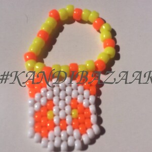 Puede incluir: Un brazalete de cuentas amarillas y naranjas con un dije de cuentas blancas y naranjas que dice "#KANDIBAZAAR".