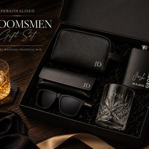 May include: A black groomsmen gift set in a box. The set includes a flask, sunglasses, a wash bag, and a rocks glass. The flask and glass are engraved with a name and date. The box is labelled "Personalised Groomsmen Gift Set".
