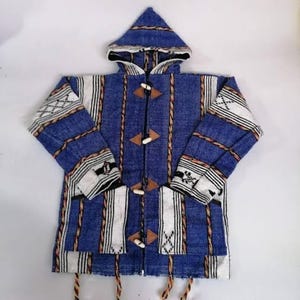 May include: A blue hooded jacket featuring white vertical stripes and brown rope-like accents. The garment includes a hood, long sleeves, two front pockets, and four toggle closures with triangular brown patches on the front placket.