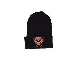 May include: Black beanie with a red and white clown face graphic.