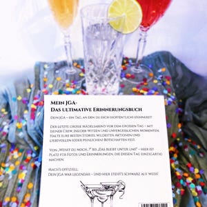 K&ouml;nnte beinhalten: Eine wei&szlig;e Karte mit schwarzem Text, der "Mein JGA - Das Ultimative Erinnerungsbuch" und "Dein JGA - Ein Tag, an den du dich (hoffentlich) erinnerst!" lautet. Die Karte hat eine Schwarzwei&szlig;illustration von drei Martini-Gl&auml;sern mit Oliven. Die Karte liegt auf einem Tisch mit Konfetti.
