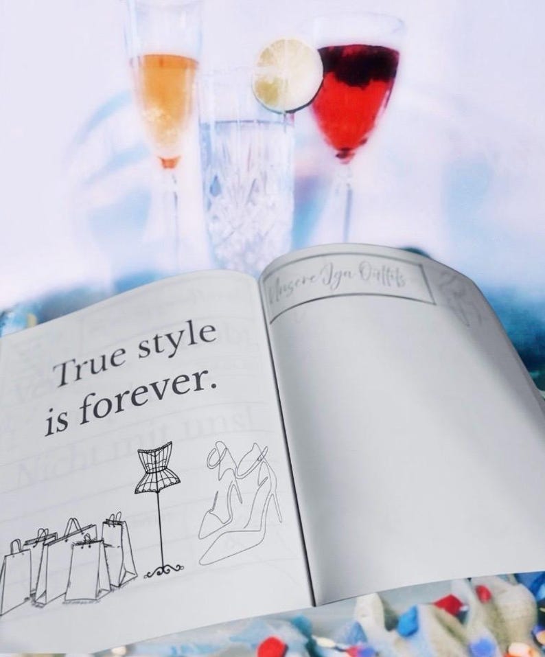 K&ouml;nnte beinhalten: Ein offenes Notizbuch mit dem Text "True style is forever." auf der linken Seite. Die rechte Seite hat einen handschriftlichen Titel "Choose Your Outfits" und ist leer. Das Notizbuch liegt auf einem Tisch mit zwei Gl&auml;sern Getr&auml;nken und einer Limettenscheibe im Hintergrund.