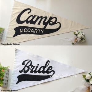 May include: Two triangular pennants, one in natural beige and one in white, both featuring black lettering. The top pennant displays the text Camp MCCARTY, while the bottom pennant displays the word Bride. Both pennants have a banner graphic.