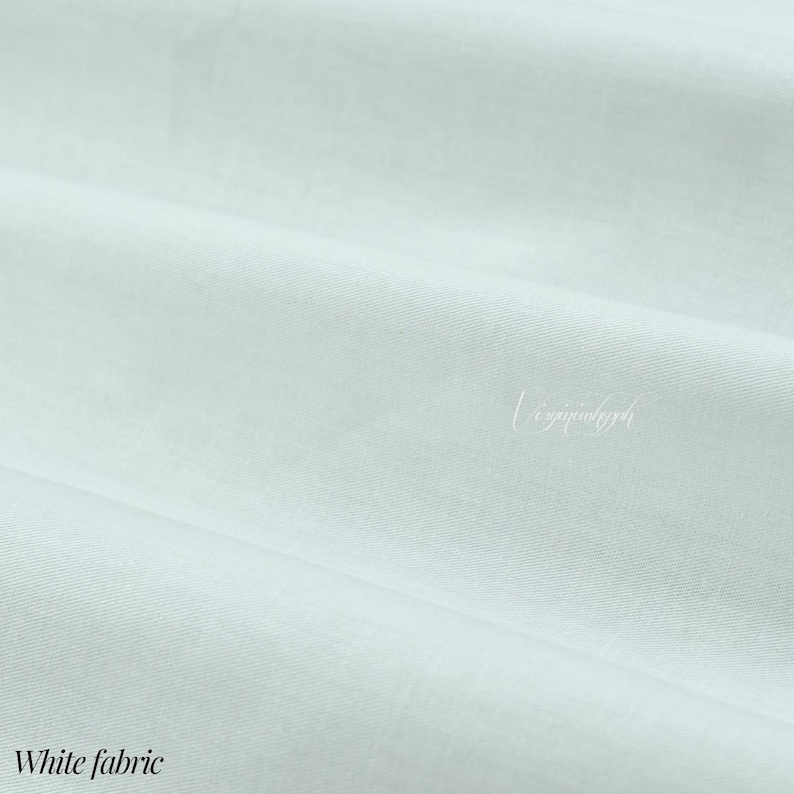 K&ouml;nnte beinhalten: Ein einfarbiger wei&szlig;er Stoff mit einer glatten, fein gewebten Textur, der weiche, diagonale Falten auf der Oberfl&auml;che aufweist. Das Material zeigt ein sauberes, gleichm&auml;&szlig;iges Erscheinungsbild mit einem subtilen Glanz und enth&auml;lt den kursiven Text Virginymph.