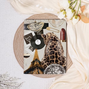 May include: A collage featuring a leopard print, a gold-toned melting clock, vinyl records, a lipstick, a disco ball, and the Eiffel Tower. The arrangement is set against a neutral background with floral accents and a decorative circular mat.