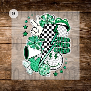 May include: A colorful graphic with a cheerleading theme. It features a peace sign, pom-poms, a megaphone, a lightning bolt, a smiley face, hearts, and the word "CHEER" repeated three times. The design incorporates green, black, and white elements.