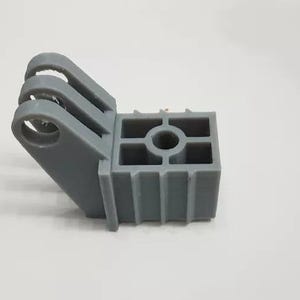 Può includere: Un supporto GoPro in plastica grigia con un connettore a tre punte e una base rettangolare.